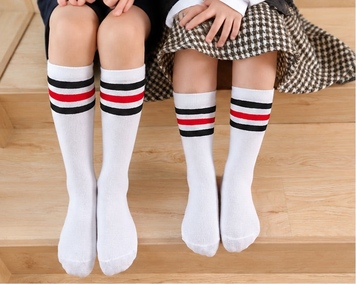 LIUMI Kids Premium Striped Knee High School Socks in white with red and black stripes, worn by two children in school uniform